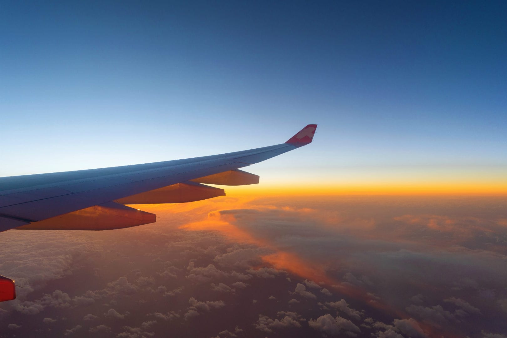 Wing of plane over a sunset.